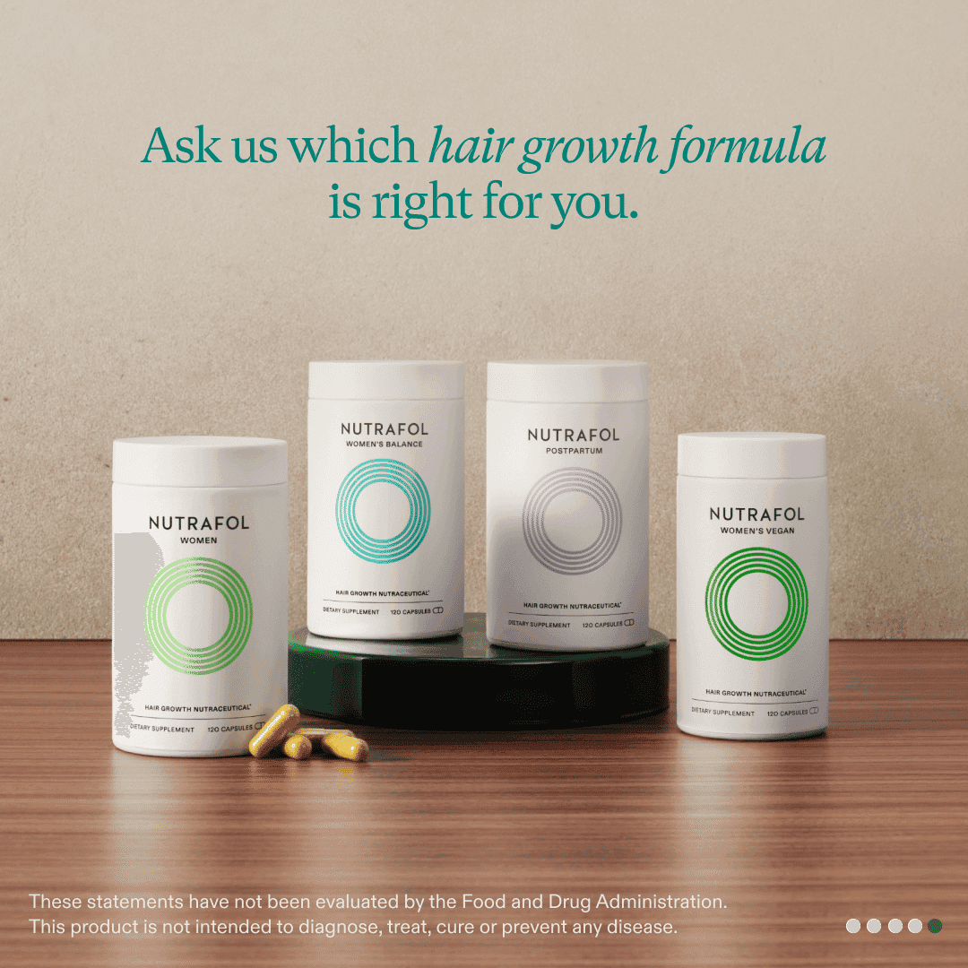 Four Nutrafol hair growth products with capsules on a wooden surface.